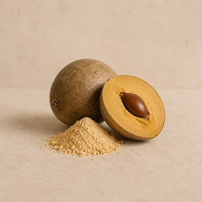 Whole and halved lucuma fruit beside a mound of lucuma powder